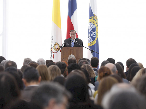 Rector Ignacio Sánchez dando su discurso en un podio frente al público.