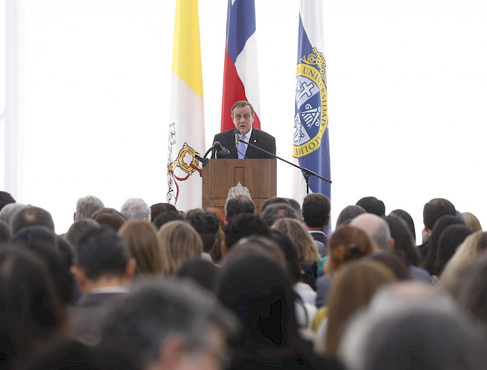 Rector Ignacio Sánchez dando su discurso en un podio frente al público.