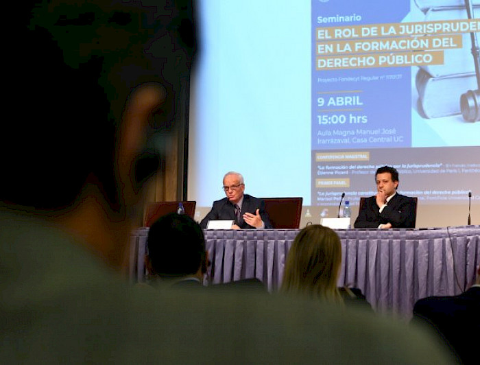 A la izquierda, el profesor de Derecho Público de la Universidad de París I Panthéon-Sorbonne, Étienne Picard, durante su ponencia  “La formación del derecho público por la jurisprudencia”, y el decano de la Facultad de Derecho, Gabriel Bocksang.