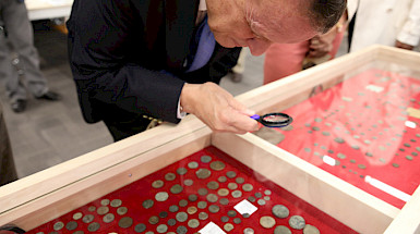 El rector Sánchez observa las colecciones en el Gabinete numismático UC.  Foto Karina Fuenzalida