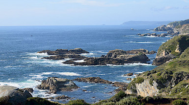 Imagen del océano y orilla de zona costera rocosa.