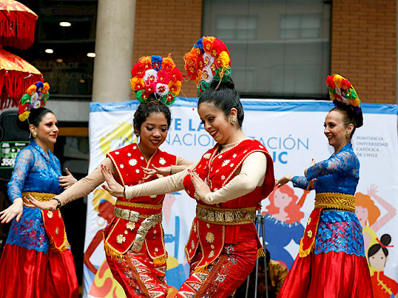 Mujeres usando coloridos trajes bailan una danza tradicional de Indonesia.