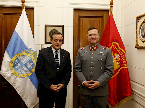 dos hombres de pie, detrás de ellos hay dos banderas