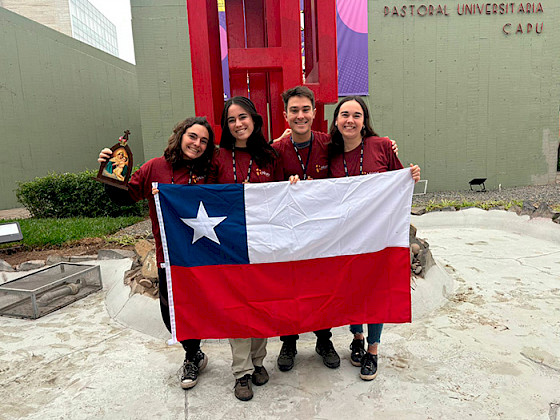 Misioneros de la UC sosteniendo una bandera chilena.