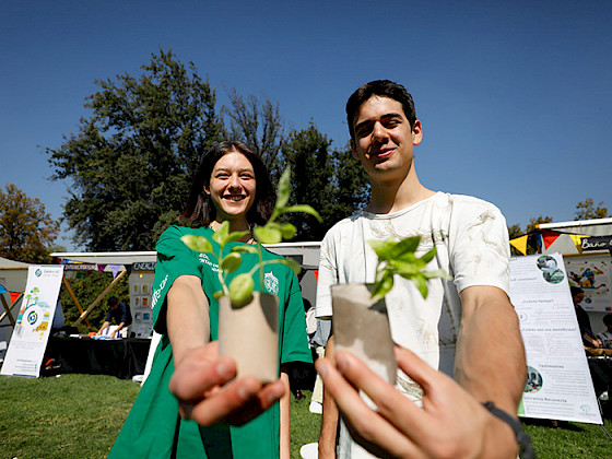 Dos jóvenes muestran unas plantas pequeñas.