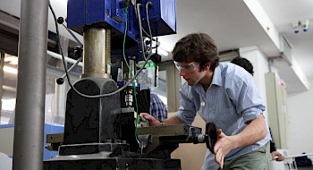 Estudiante utilizando máquina, en el marco del desarrollo científico, tecnológico y de innovación en la UC.