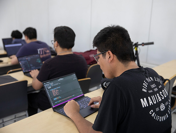 Estudiante programando en un notebook.