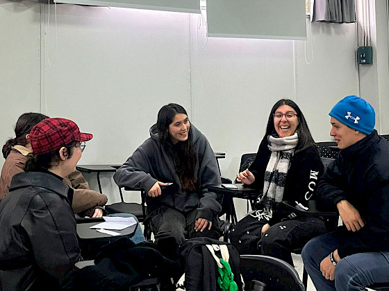 Estudiantes sentados en círculo en una sala de clases.