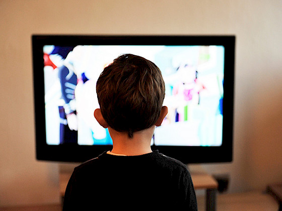 Niño de espaldas mirando una pantalla.