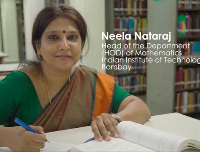 Neela Nataraj, directora del departamento de Matemáticas del Instituto Indio de Tecnología de Bombay (IIT Bombay), mirando a la cámara, con dos cuadernos abiertos frente a ella.