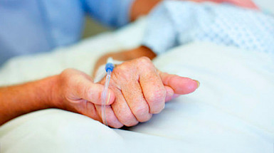 Mano que sostiene la mano de un paciente