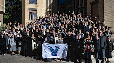grupo asistentes a conferencia posa en exterior de edificio