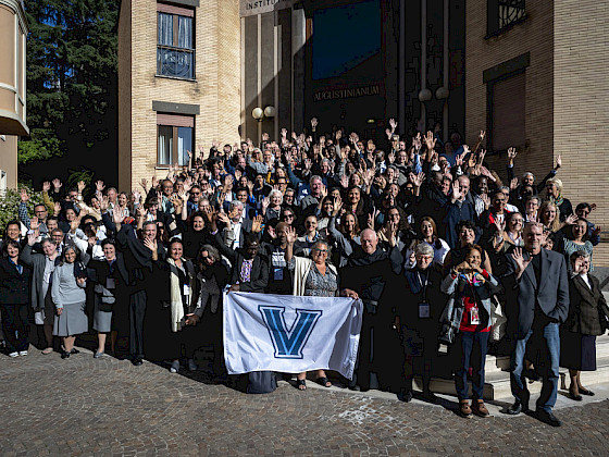 grupo asistentes a conferencia posa en exterior de edificio