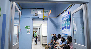 Pacientes sentados en un pasillo de hospital