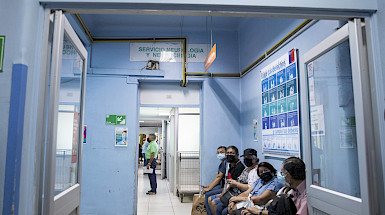Pacientes sentados en un pasillo de hospital