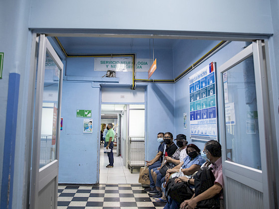 Pacientes sentados en un pasillo de hospital