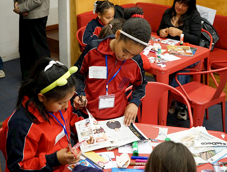 Niñas recortan imágenes impresas  