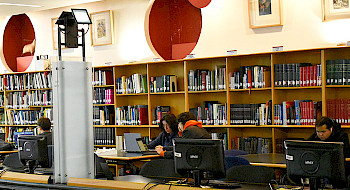 Estudiantes trabajando en computadores en la Biblioteca UC.