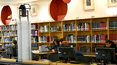 Estudiantes trabajando en computadores en la Biblioteca UC.