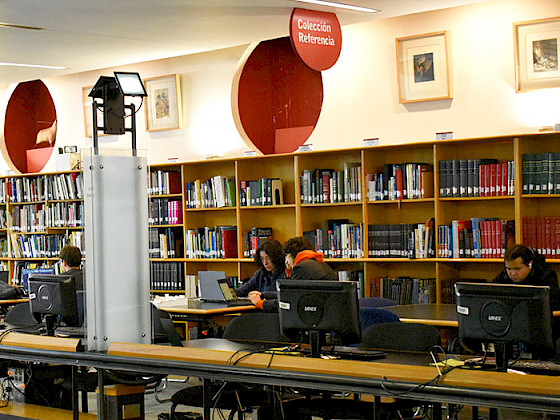 Estudiantes trabajando en computadores en la Biblioteca UC.