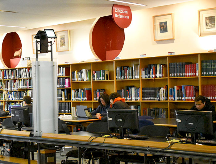 Estudiantes trabajando en computadores en la Biblioteca UC.