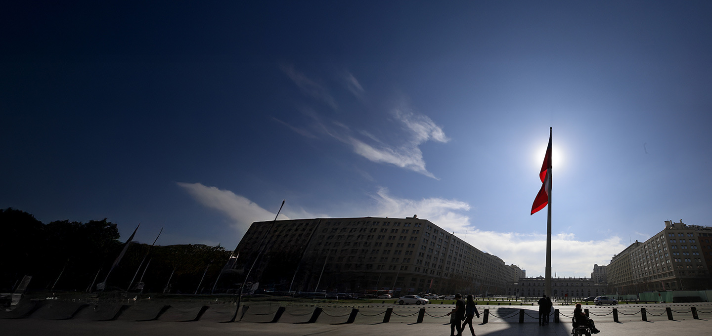 Bandera chilena con La Moneda de fondo.