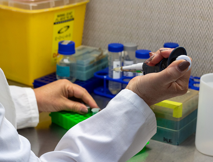 Investigadora manipulando instrumentos de laboratorio.