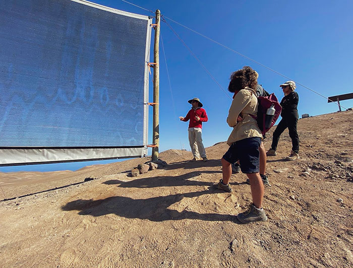 Investigador y estudiantes junto a atrapanieblas en la Estación Atacama UC.