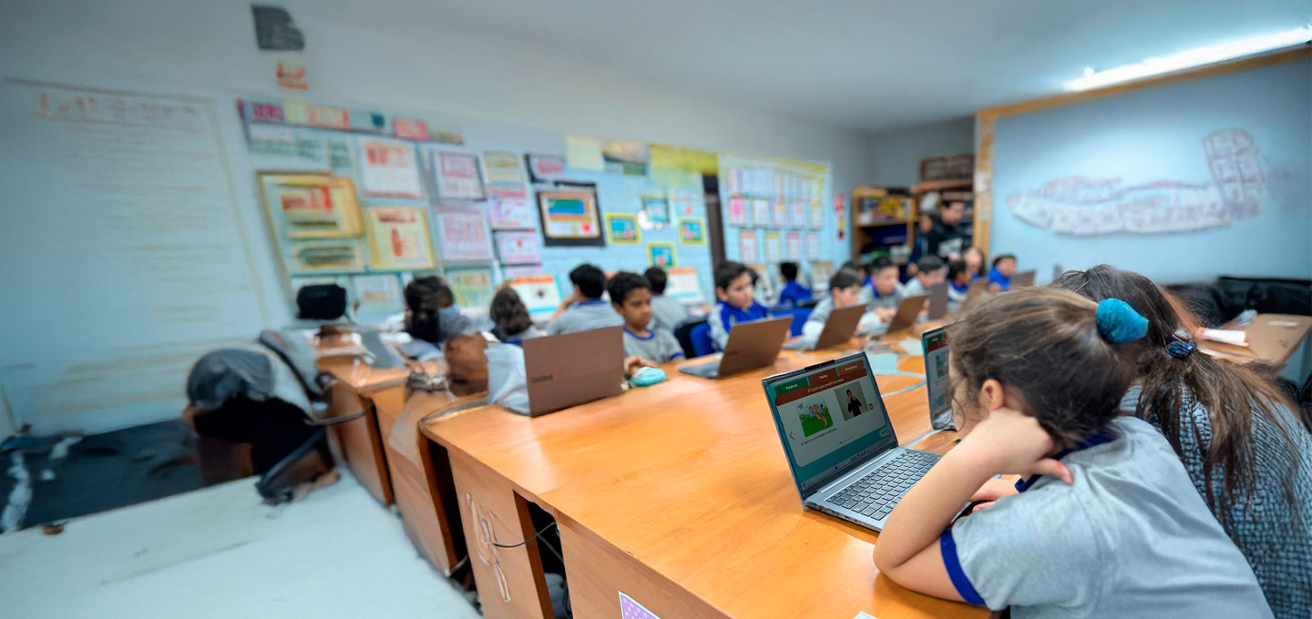 Escolares usando el programa Sueñaletras en sus computadores en una sala de clases.