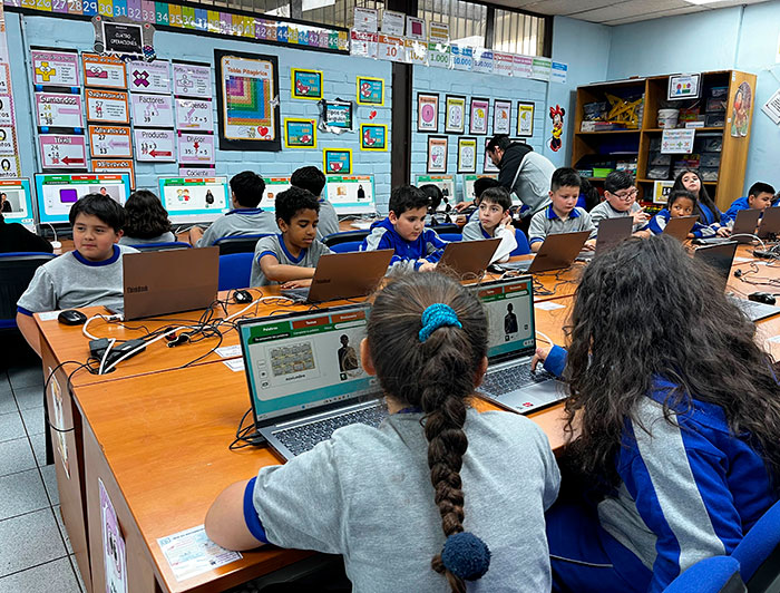 Escolares usando el software Sueñaletras en computadores en una sala de clases.