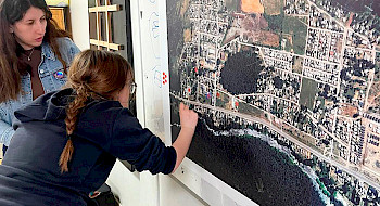 Alumna muestra un punto en un mapa.