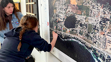 Alumna muestra un punto en un mapa.