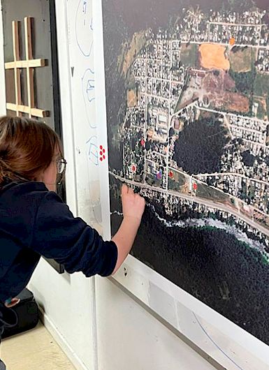 Alumna muestra un punto en un mapa.