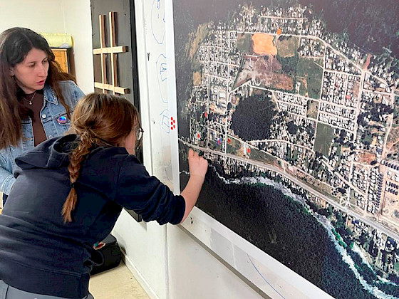 Alumna muestra un punto en un mapa.