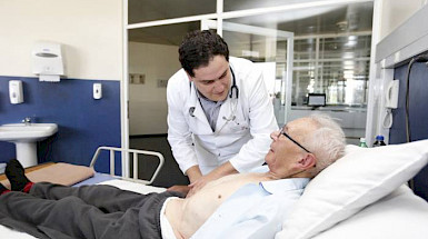 Un médico de la Pontificia Universidad Católica de Chile ausculta a un paciente de la tercera edad.
