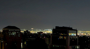 Edificios en primer plano a oscuras, durante un apagón parcial en Santiago.