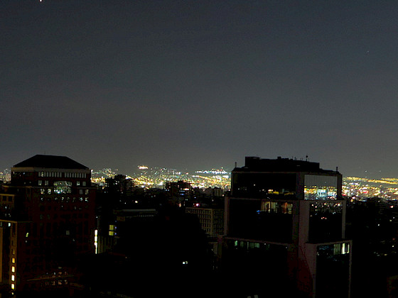 Edificios en primer plano a oscuras, durante un apagón parcial en Santiago.