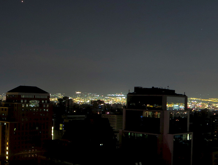 Edificios en primer plano a oscuras, durante un apagón parcial en Santiago.