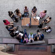 Estudiantes reunidos en círculo en un patio.
