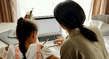 Madre e hija frente a un computador