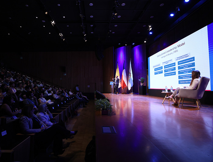Conferencista en escenario y público de Summit Internacional de Educación UC.