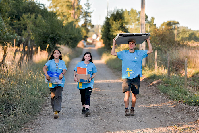 Jóvenes voluntarios de Capilla País llevando materiales 