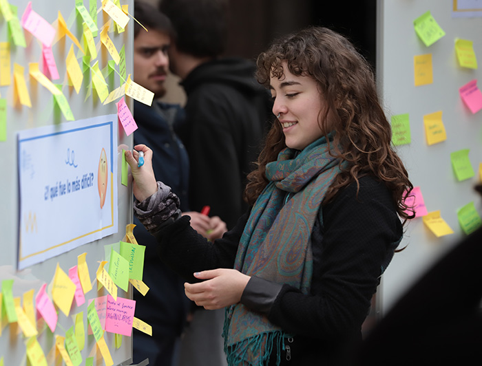 Alumna colocando un post-it en un panel