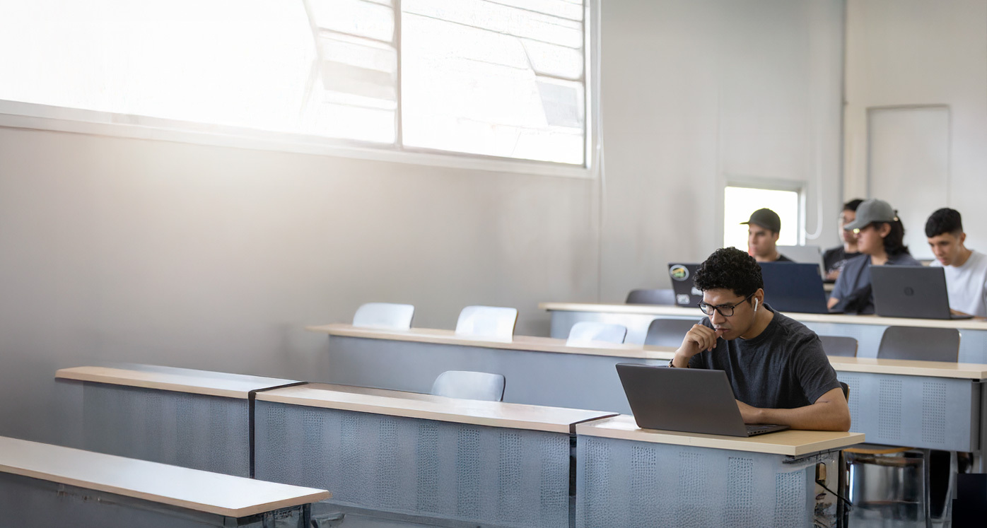 Estudiantes trabajando en computadores en una sala de clases