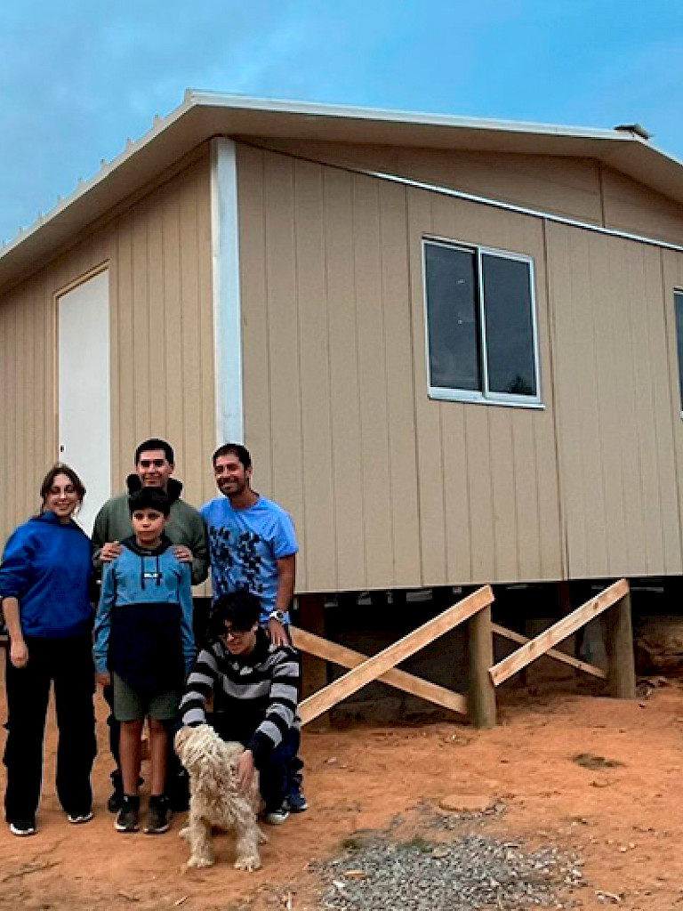 Familia junto a su nueva vivienda en Biobío.