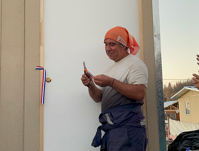 Vecino de Lirquén corta cinta inaugurando su vivienda de emergencia.