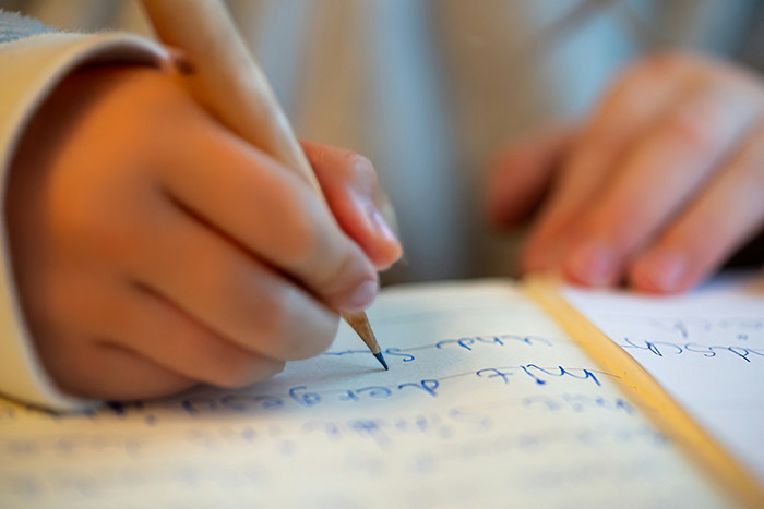 Manos infantiles escribiendo a mano