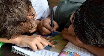 Niños pintan en un libro