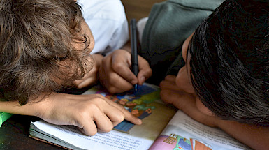 Niños pintan en un libro
