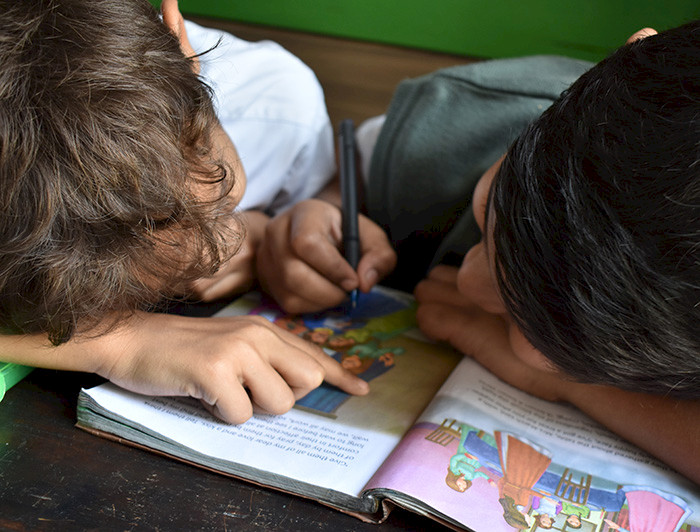Niños pintan en un libro